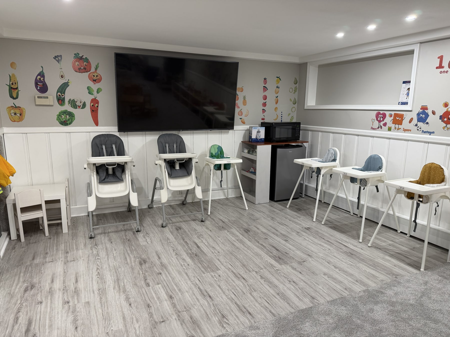 The actual Bluebird Learning Nest dining area with high chairs, a child-sized table, and food-themed wall decorations